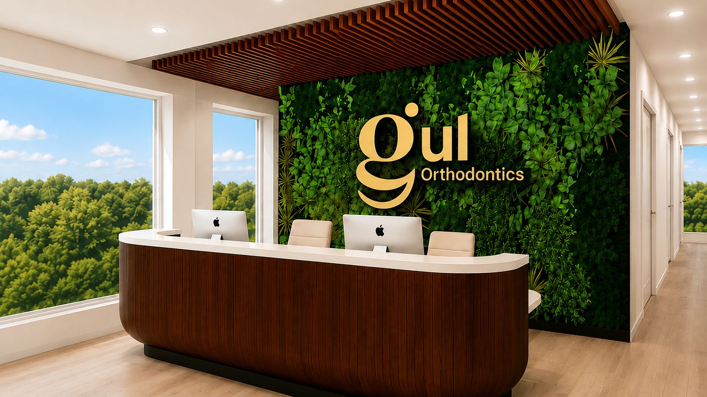 Bright Gul Orthodontics reception with a lush green living wall and the gold Gul Orthodontics logo